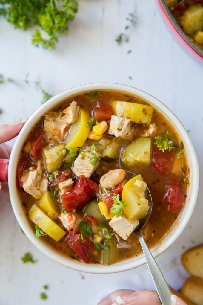 chicken soup with veggies in a bowl with a spoon