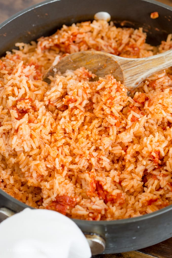 Authentic restaurant style Mexican Rice, being fluffed in the pan with a spoon