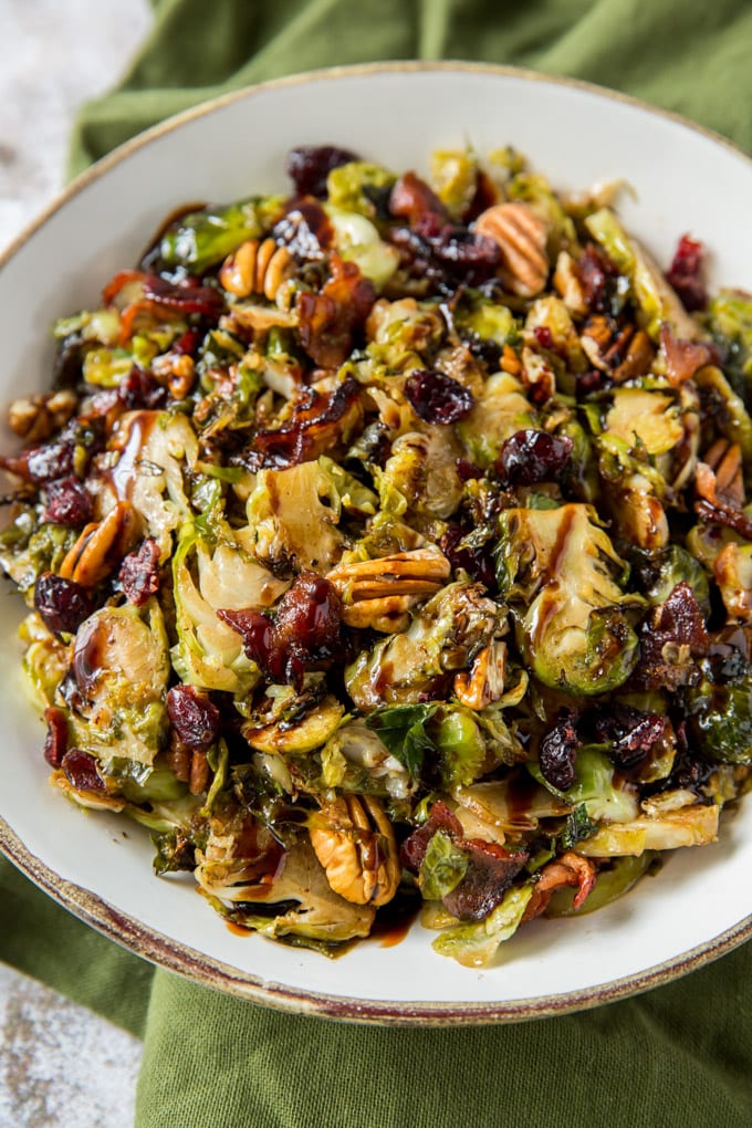 Brussels Sprouts, cranberries, pecans and bacon in a white bowl