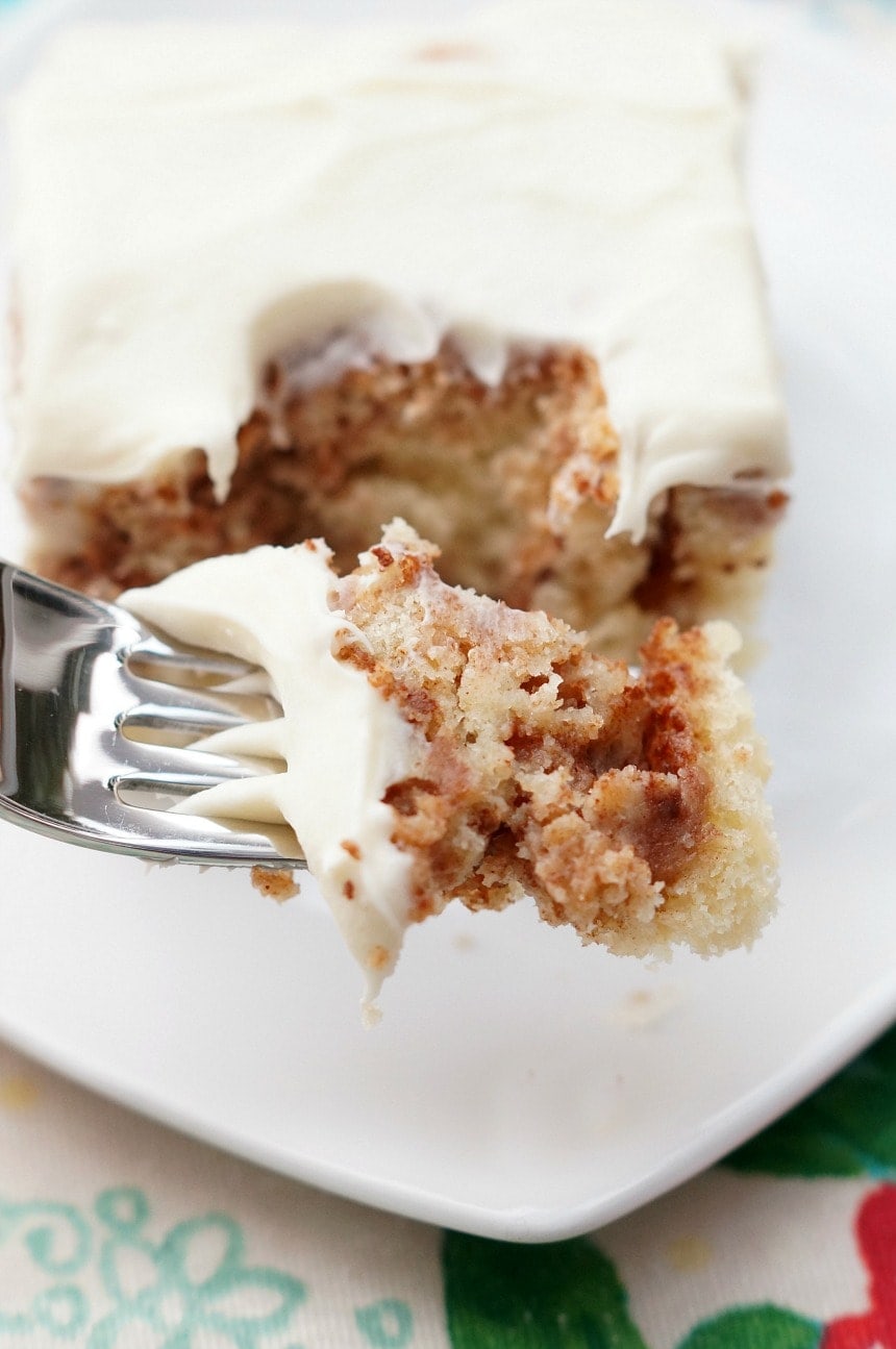  Cinnamon Roll Cake er en sjov og nem at tage på den klassiske kanelrulle! En lækker hvid kage hvirvlede med brunt sukker og kanel og derefter toppet med flødeost frosting!