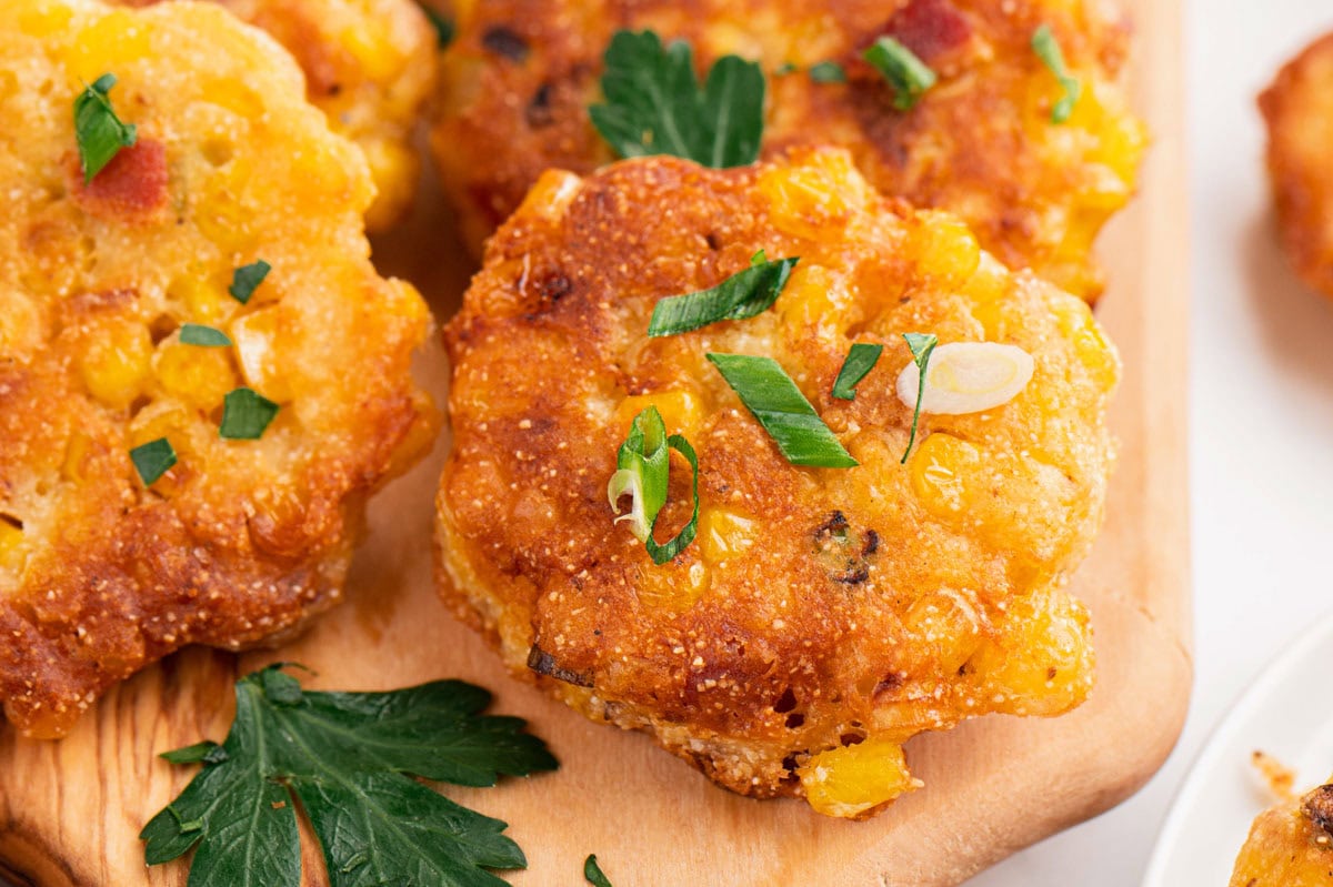 corn cakes on a wooden cutting board.