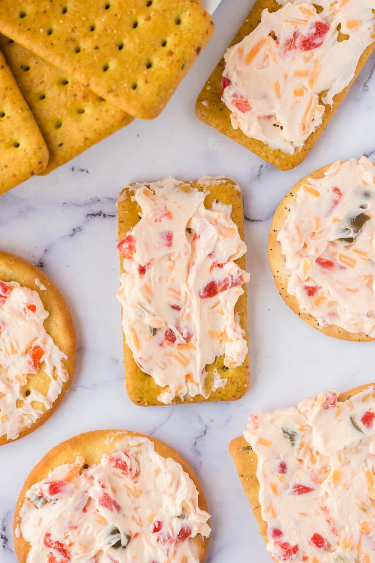 Several crackers spread out and spread with pimento cheese dip