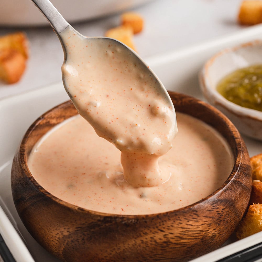 Big mac sauce in a wood bowl and with a spoon.