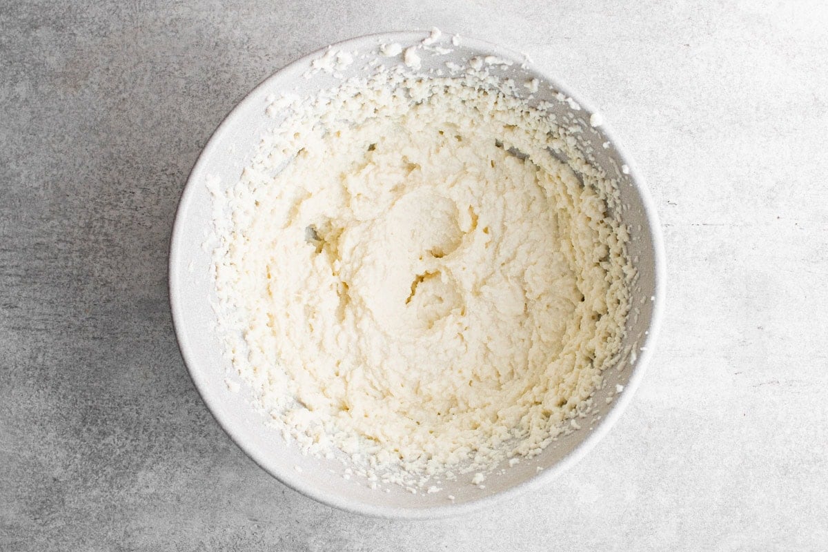 Ricotta cheese, whipped, in a bowl.