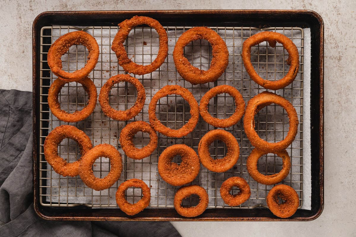 a bunch of onion rings on a rack.