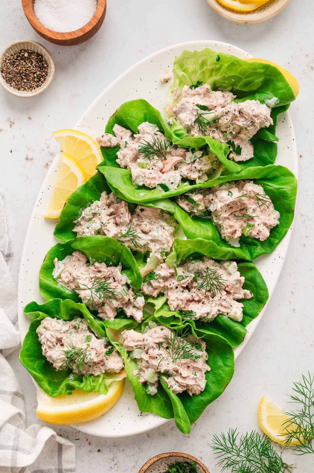 Tuna salad in lettuce cups served on a white platter.