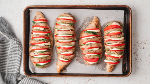 Caprese stuffed chicken breasts on a cookie sheet.