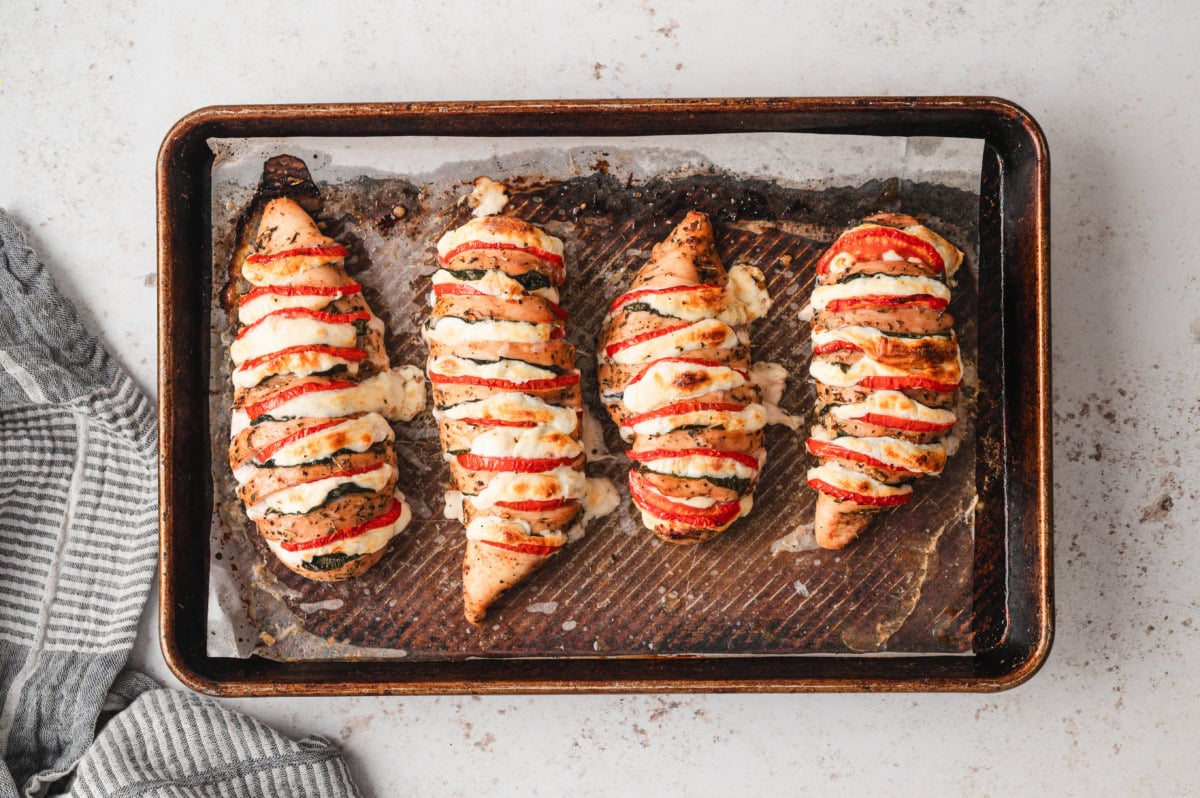 Baked caprese chicken on a baking sheet.