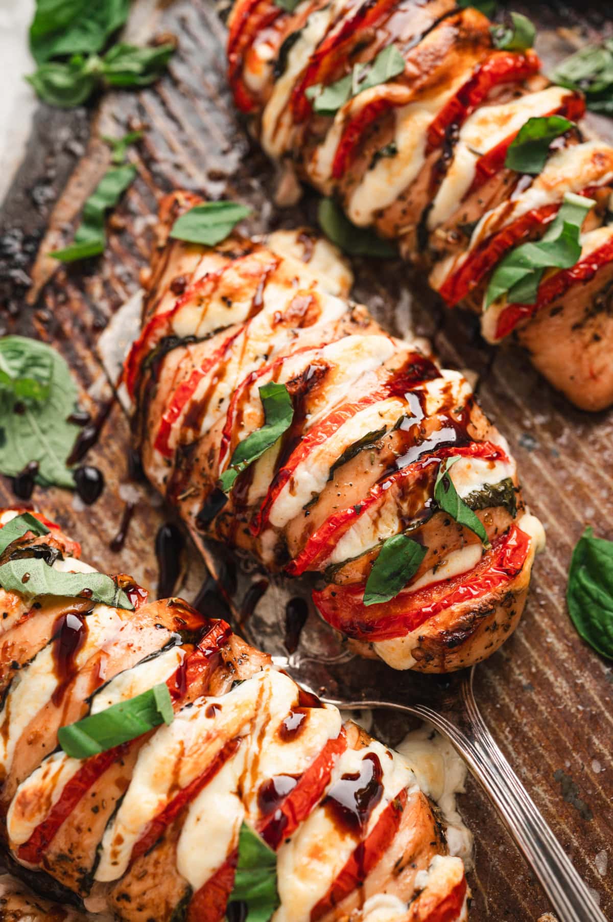 Close up of a chicken breast stuffed with mozzarella, tomatoes and basil.