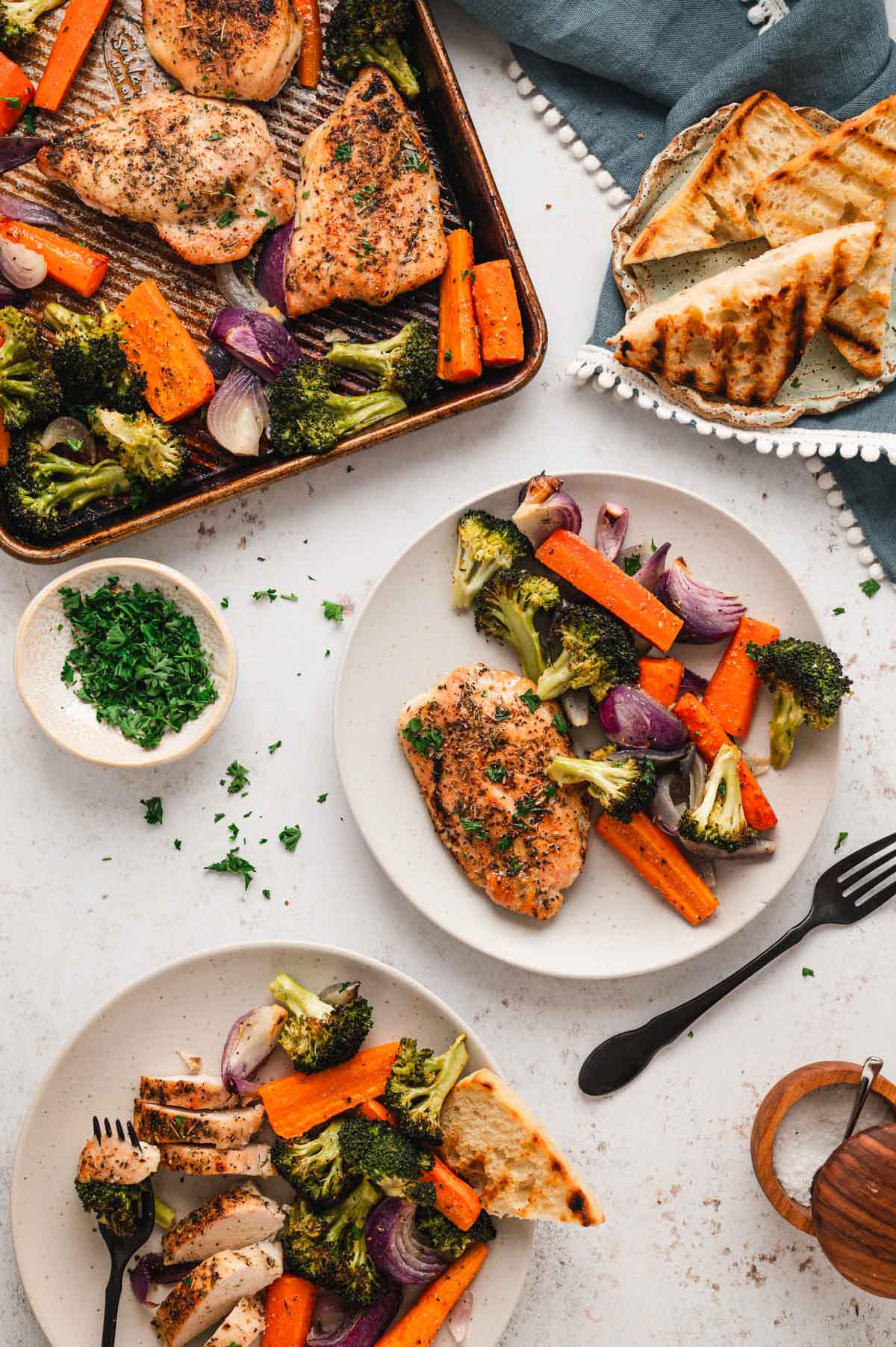 Two plates with chicken, broccoli and carrots.