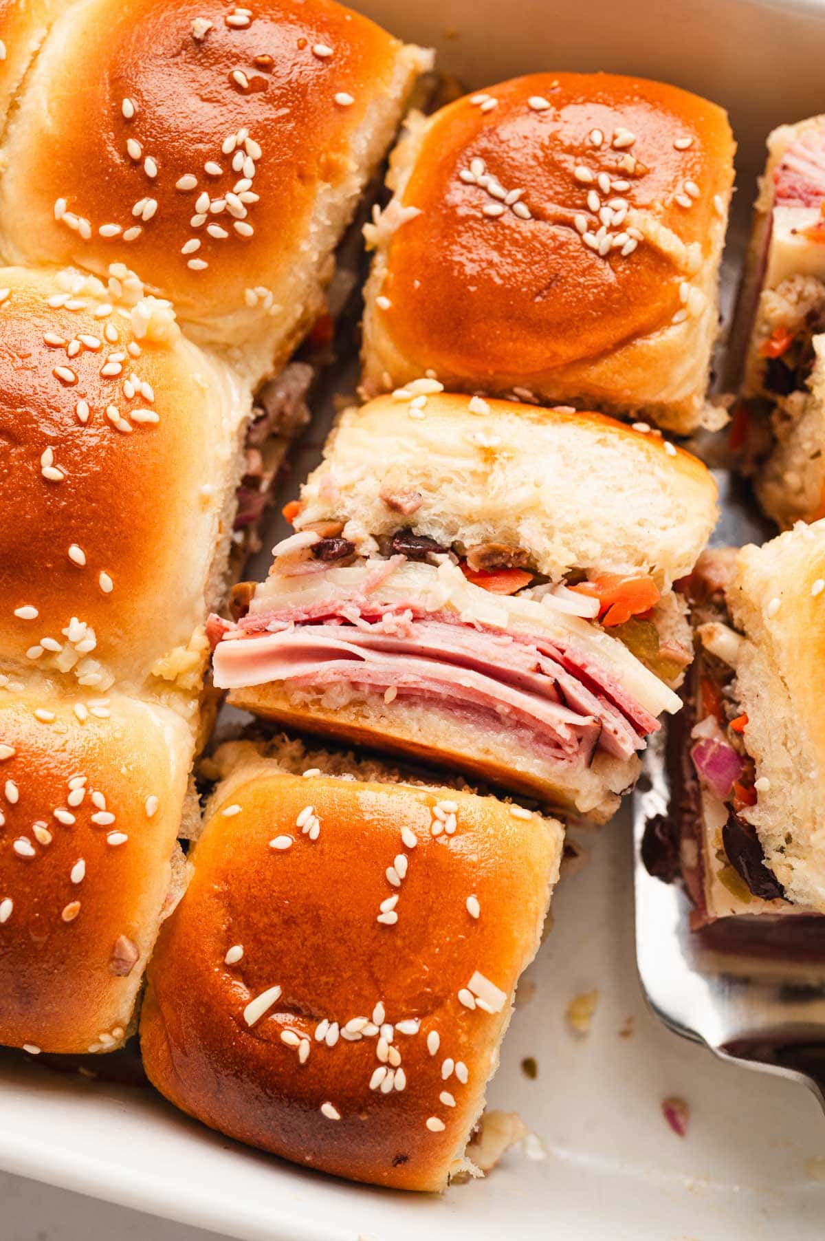 Muffuletta sliders with 2 on their sides to show the filling.