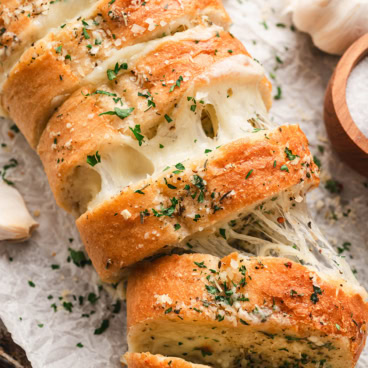 Garlic bread sliced stuffed with cheese.