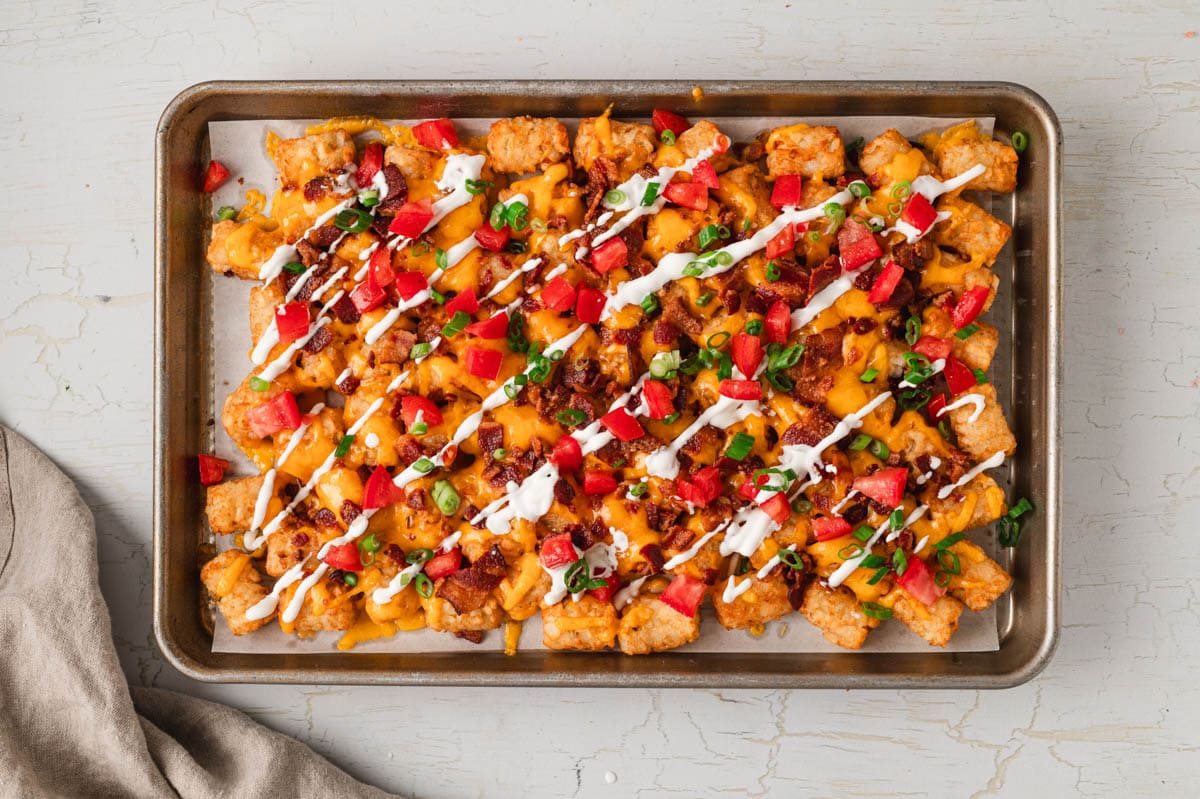 tater tots with melted cheese, bacon, diced tomatoes, green onions and sour cream.