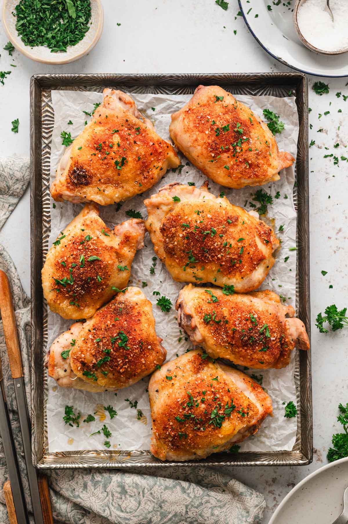 Crispy baked chicken thighs on a baking sheet.