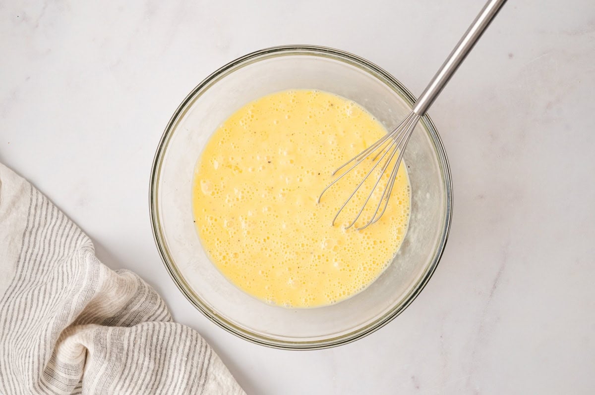 Whisked eggs in a glass bowl.