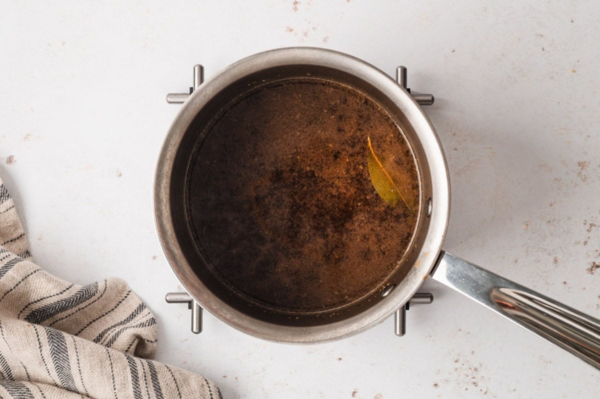 Beef stock in a saucepan.