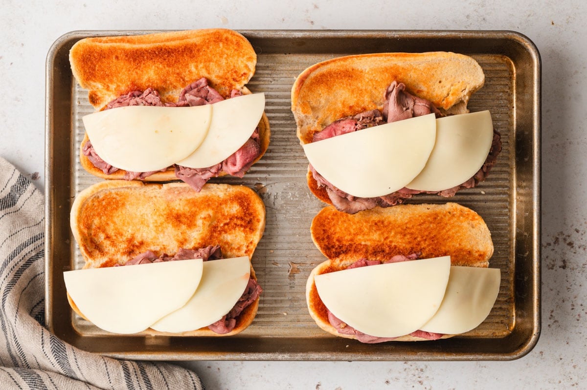 Roast beef and cheese piled onto hoagie rolls.