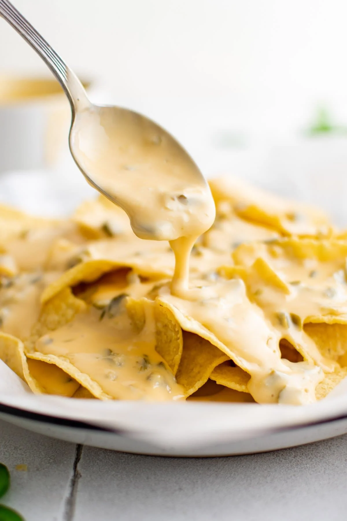 nacho cheese spooned over chips on a plate