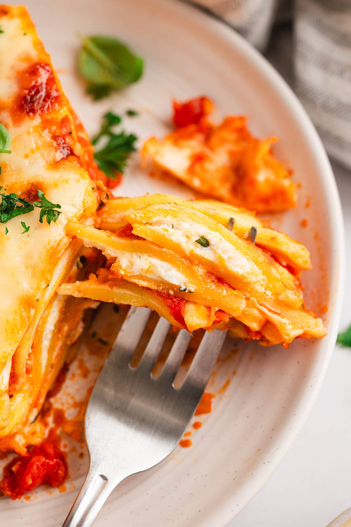 Ravioli lasagna on a plate with a fork.