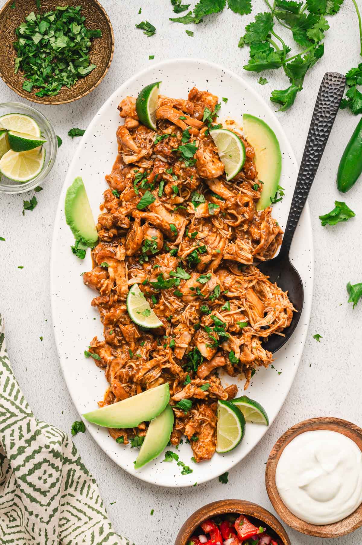 Shredded salsa verde chicken on a white.