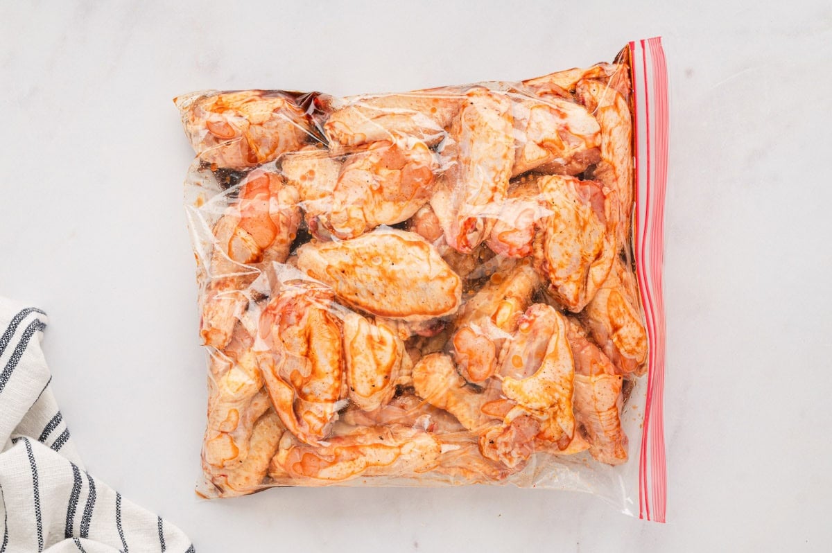 Chicken wings in a plastic bag with marinade.