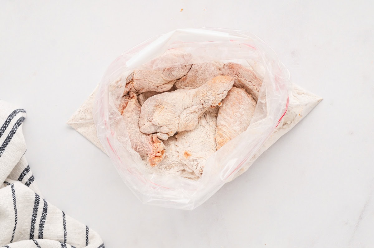 chicken wings in a ziploc bag with flour.