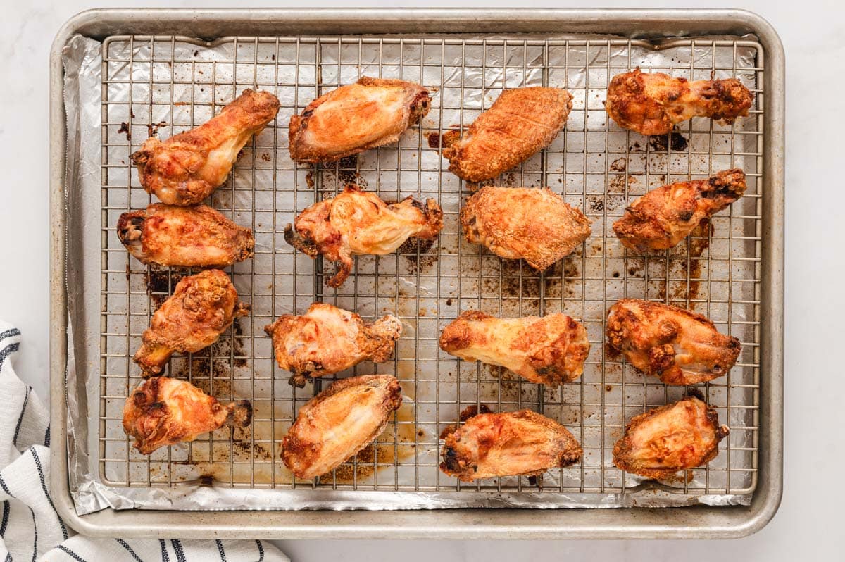 baked chicken wings on a wire rack over a baking sheet.