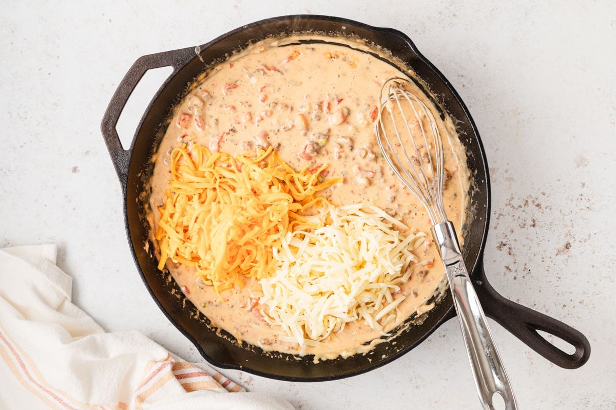 Shredded cheese on top of queso.