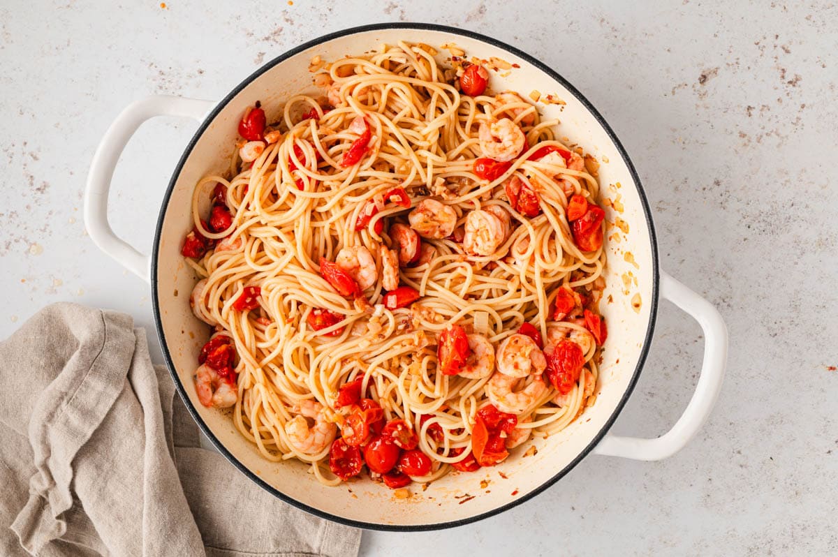 Pasta, shrimp and tomatoes in a large skillet.