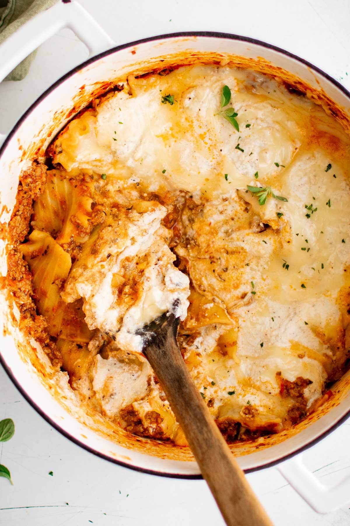 Skillet lasagna in a large pot with a wooden spoon.