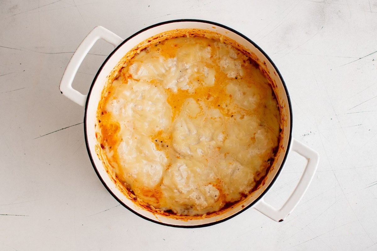 Mozzarella cheese melted on top of lasagna layers in a large pot.