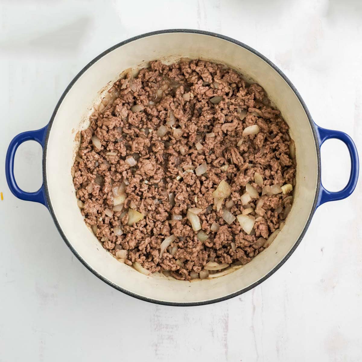 Cooked ground beef and onions in a pot.