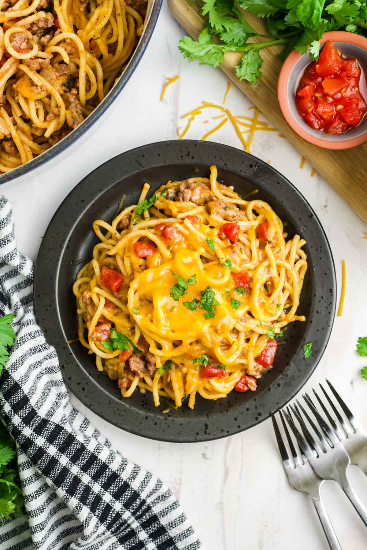 A small serving of taco spaghett on a black plate.