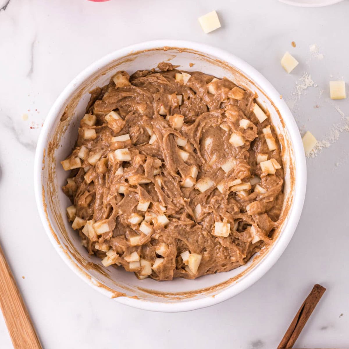 Diced apple in a cinnamon muffin batter 