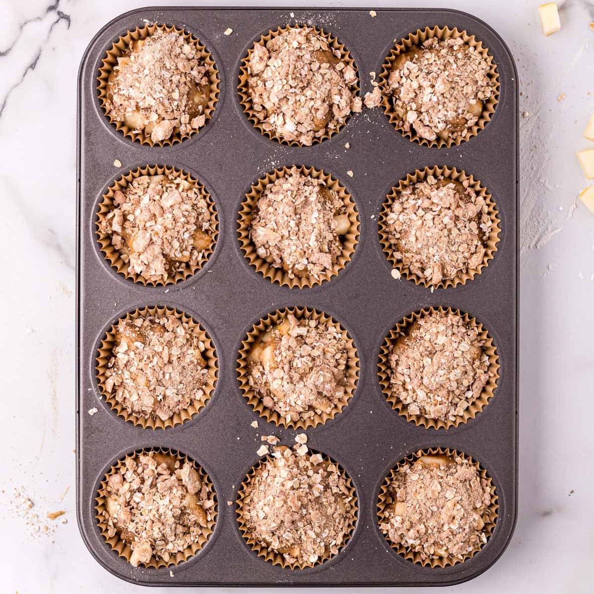 Apple muffin batter in a muffin pan