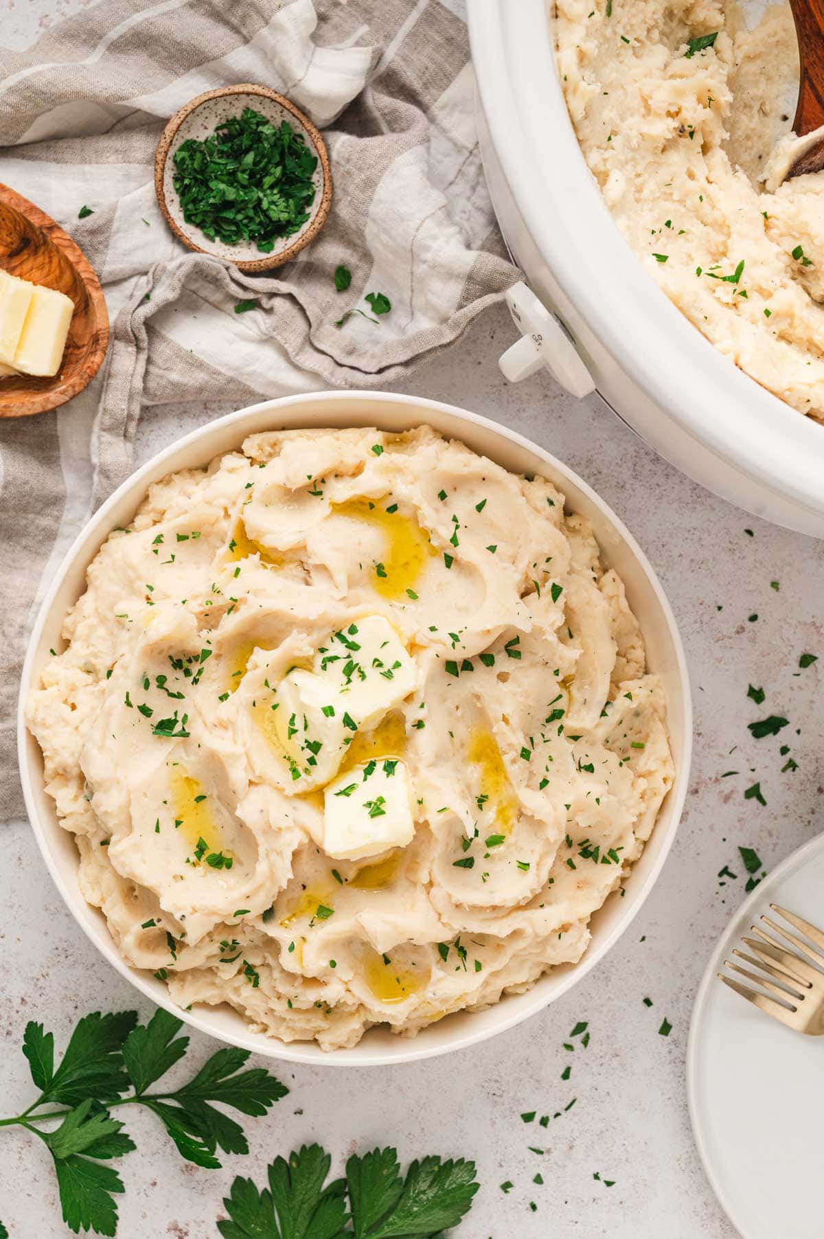 mashed potatoes with melted butter in a white bowl.