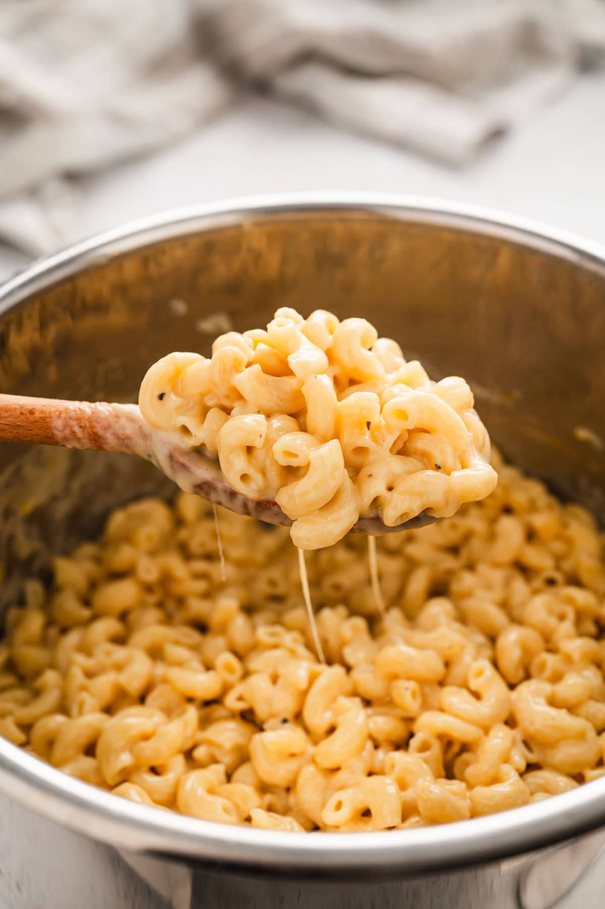 Mac and cheese on a wooden spoon.