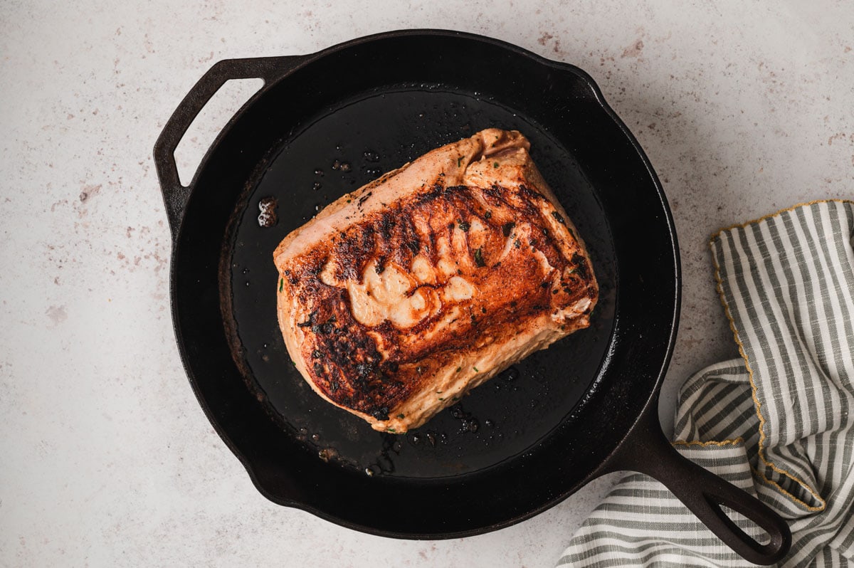 Seared pork loin in a cast iron pan.