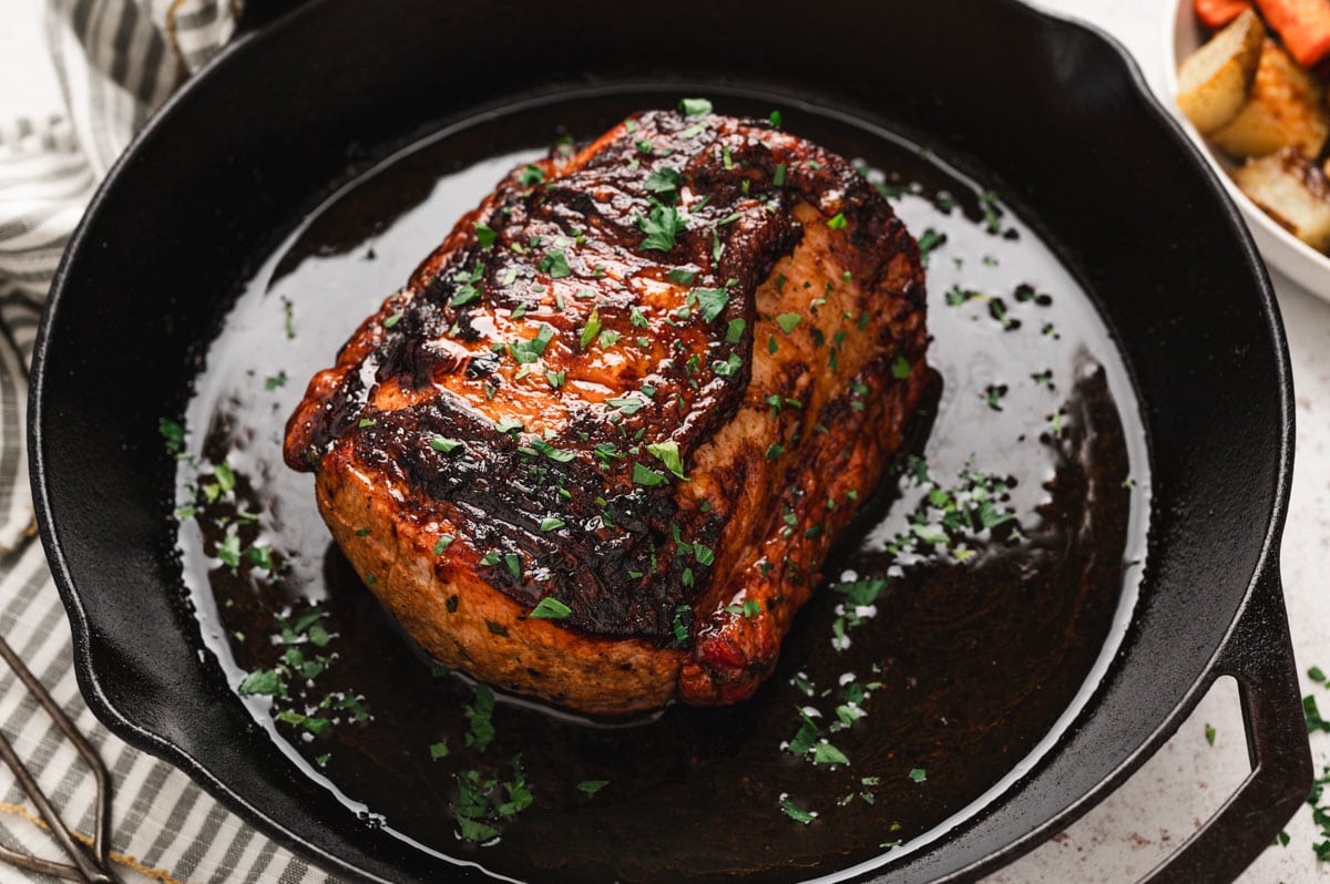 Roasted pork loin in a cast iron skillet.