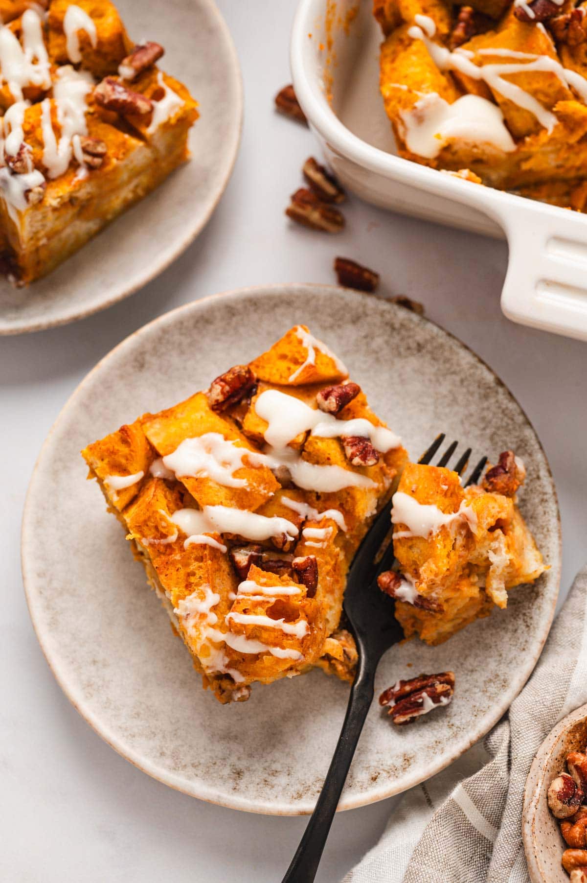 slice of pumpkin bread pudding on a plate with a fork.