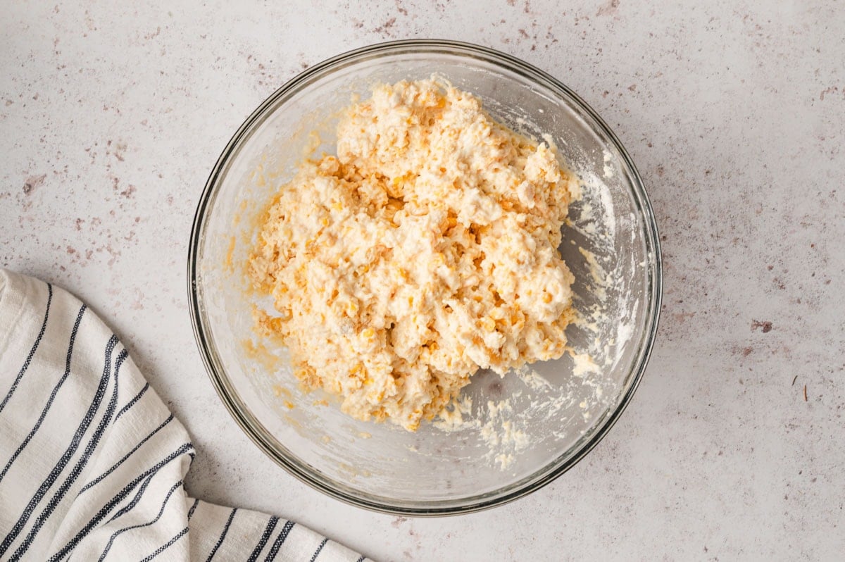 Cornbread casserole batter in a glass bowl.