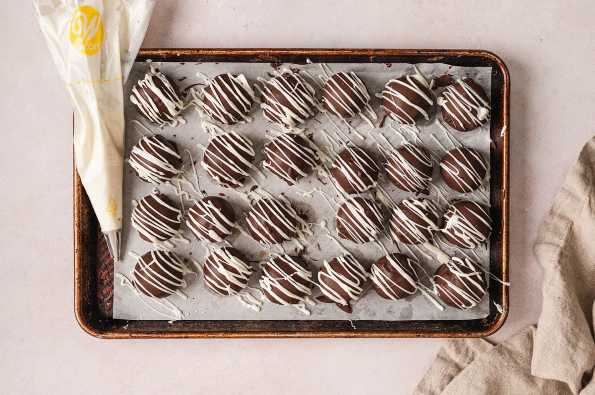 Chocolate truffles with drizzled white chocolate.