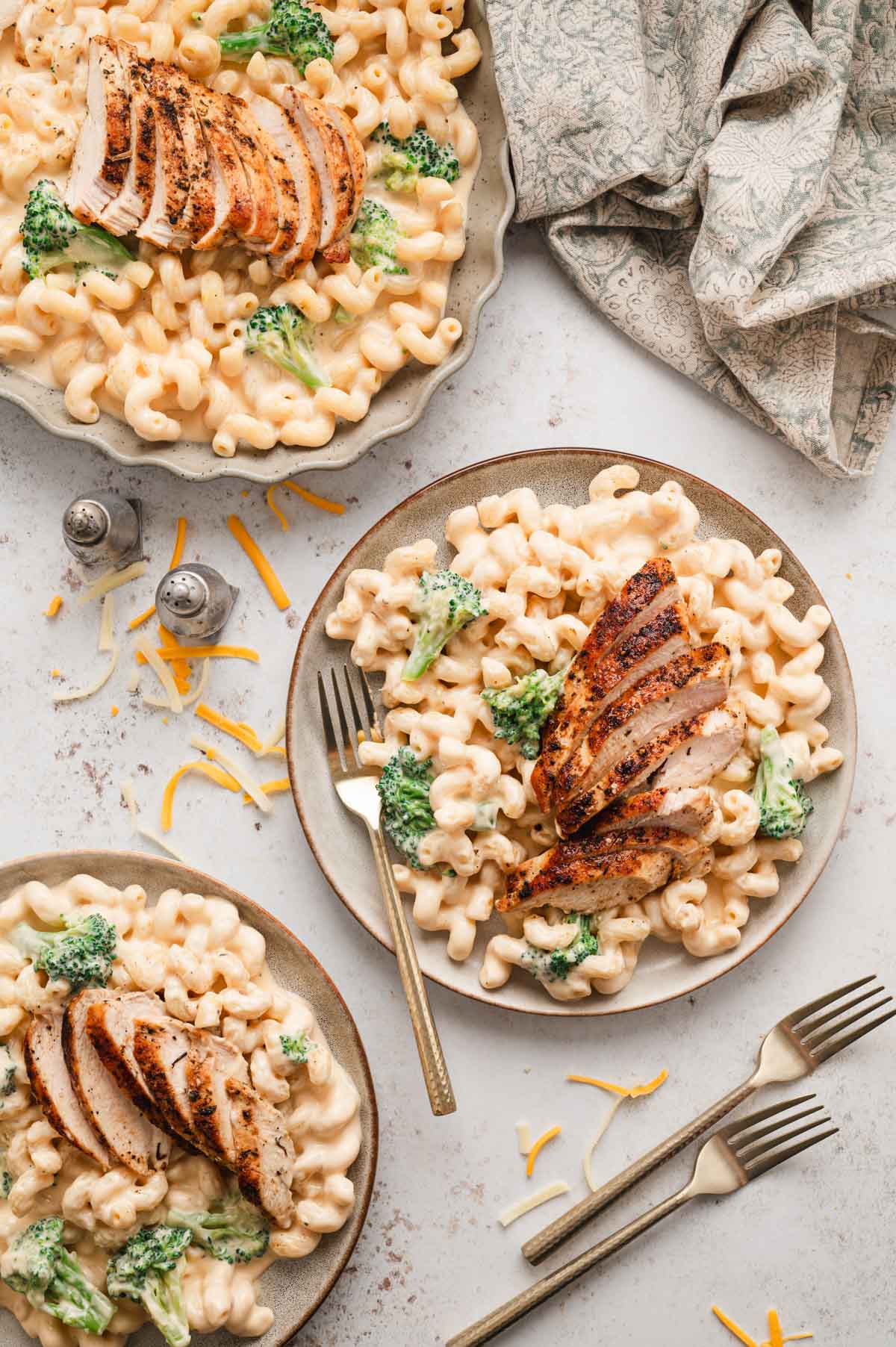 Dinner plates with chicken, broccoli mac and cheese.