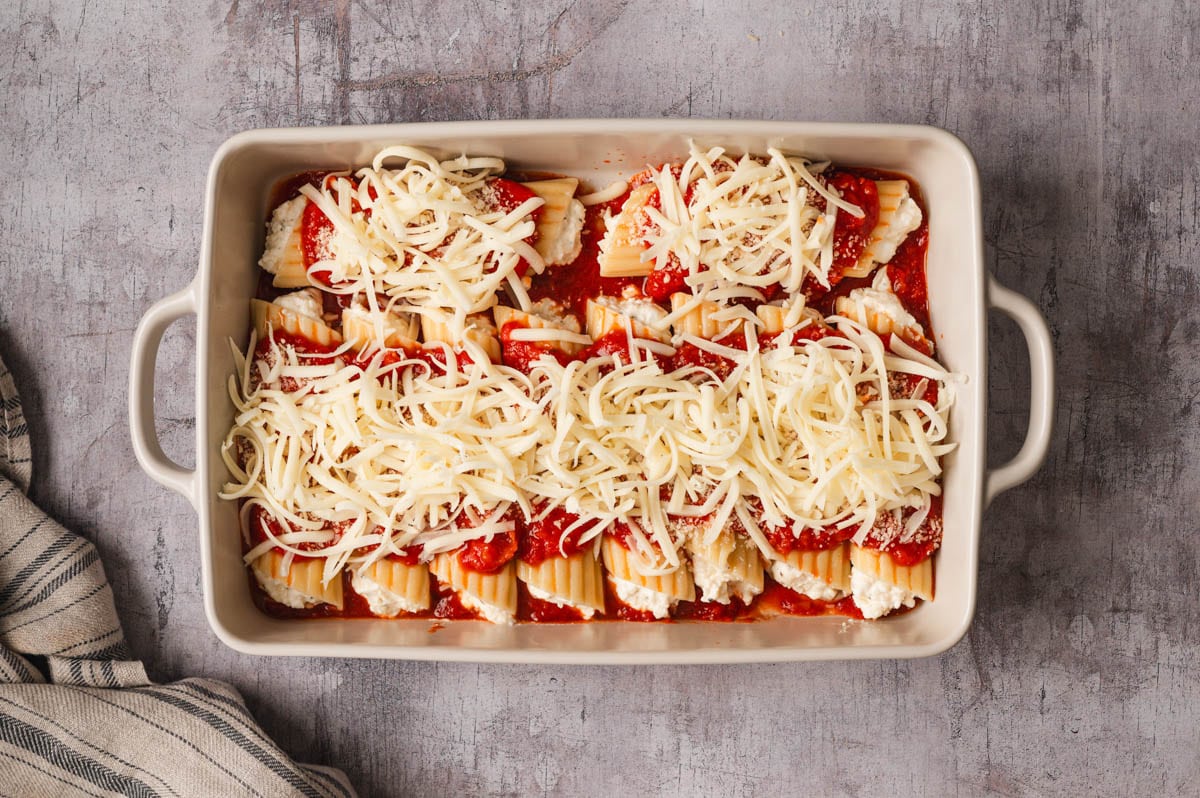 Marinara and shredded mozzarella spread over stuffed manicotti pasta,