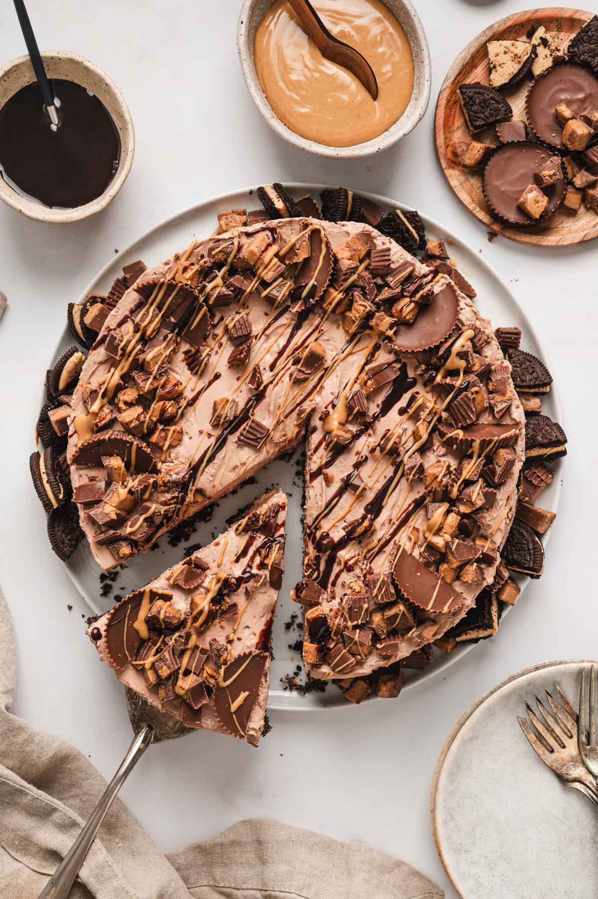 chocolate peanut butter cheese with chocolate drizzle and a serving spatula.