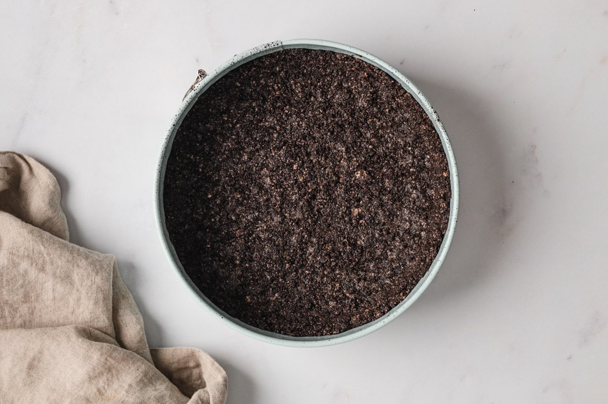 Oreo crust pressed into a pan.