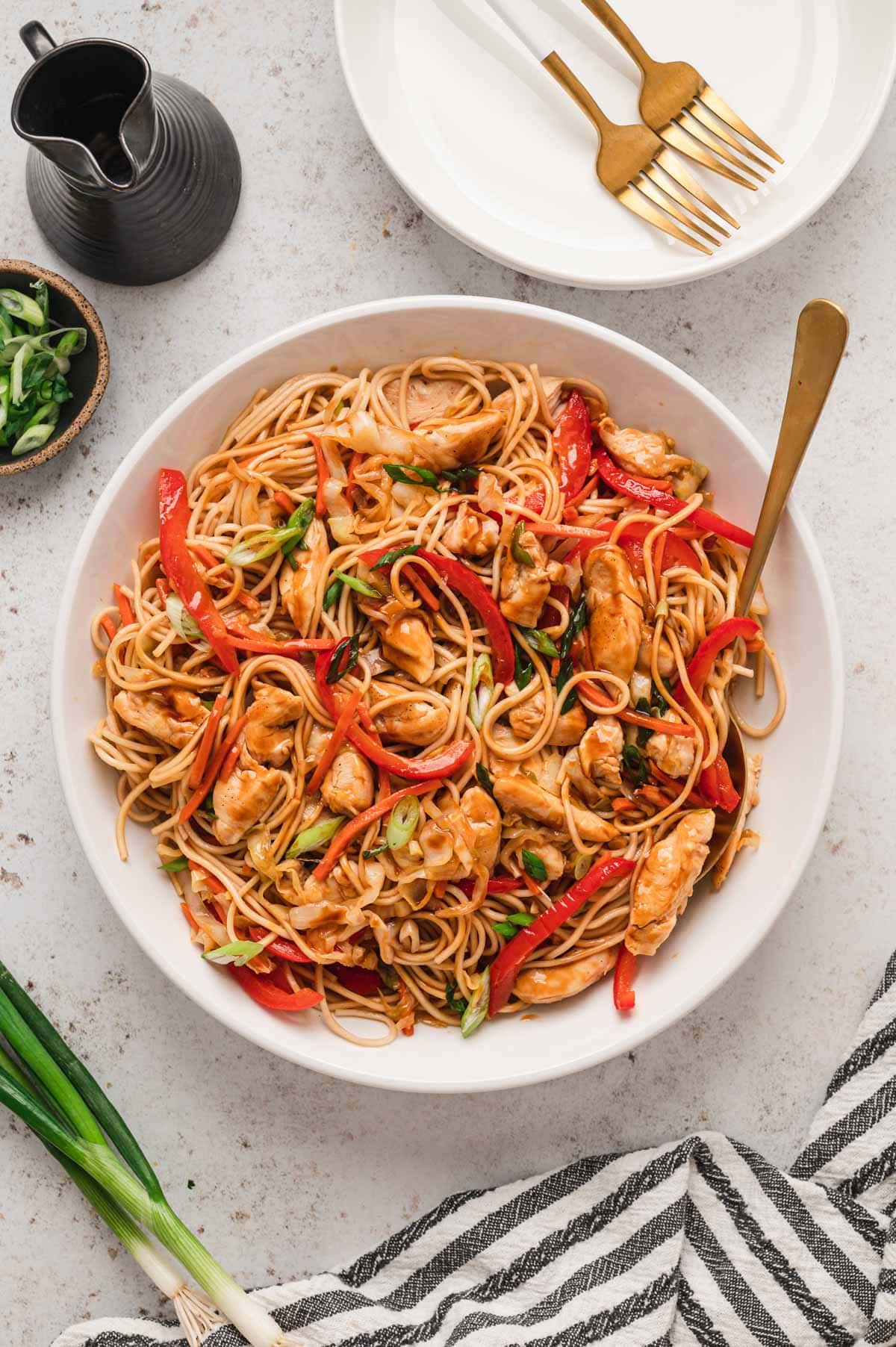 chicken yakisoba in a serving bowl with a fork.