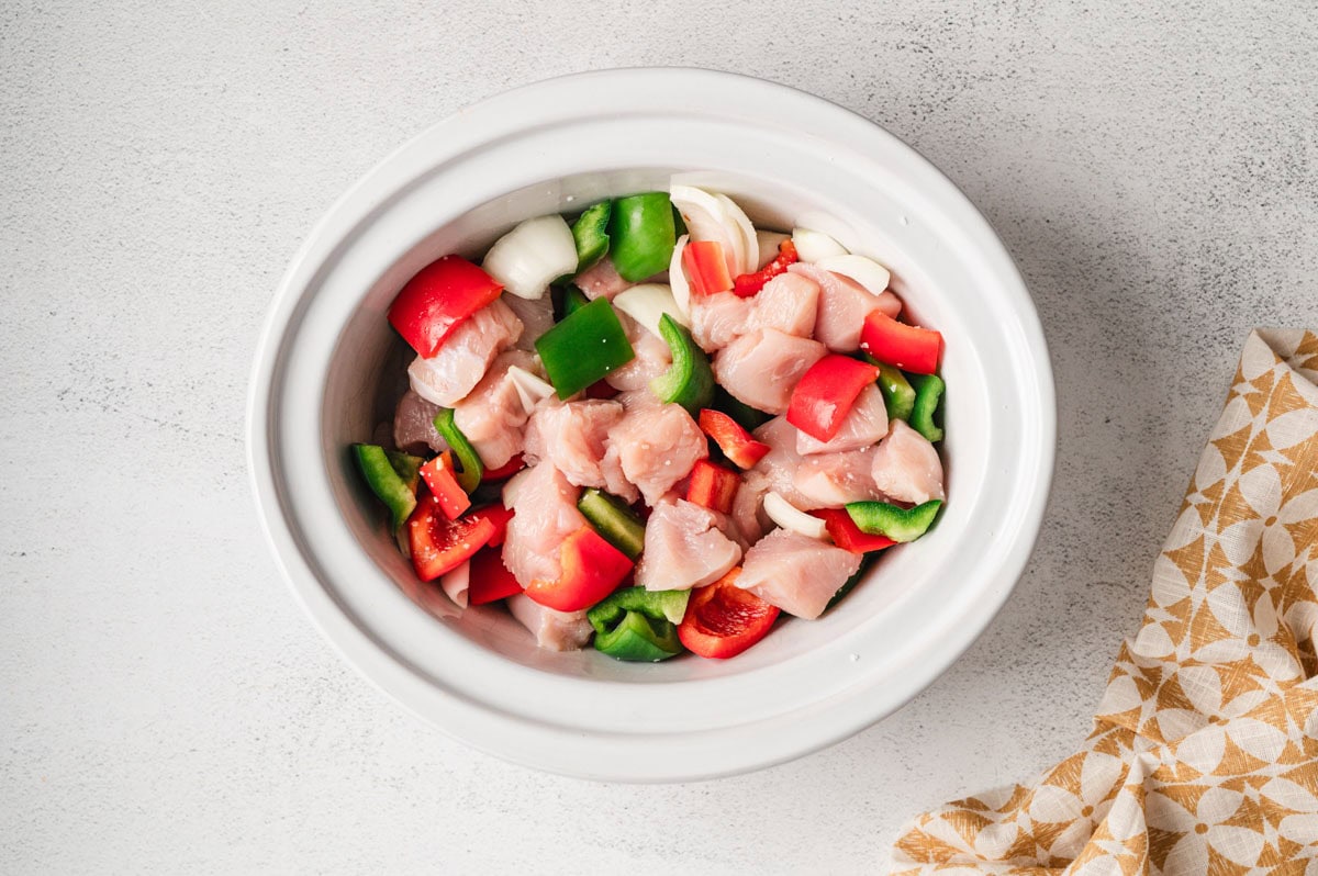 Raw chicken and vegetable in a slow cooker